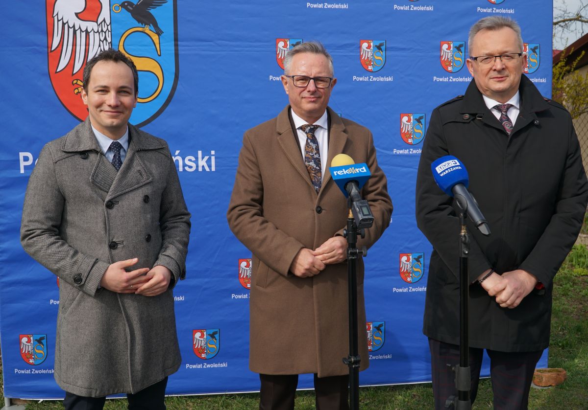 Zdjęcie przedstawia trzy osoby stojące na ściance Powiatu Zwoleńskiego